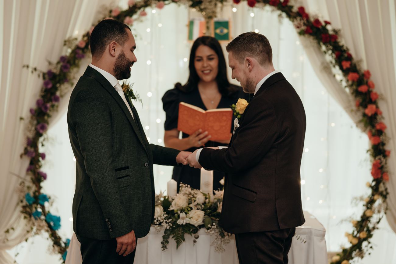 Two grooms holding hands at their ceremony