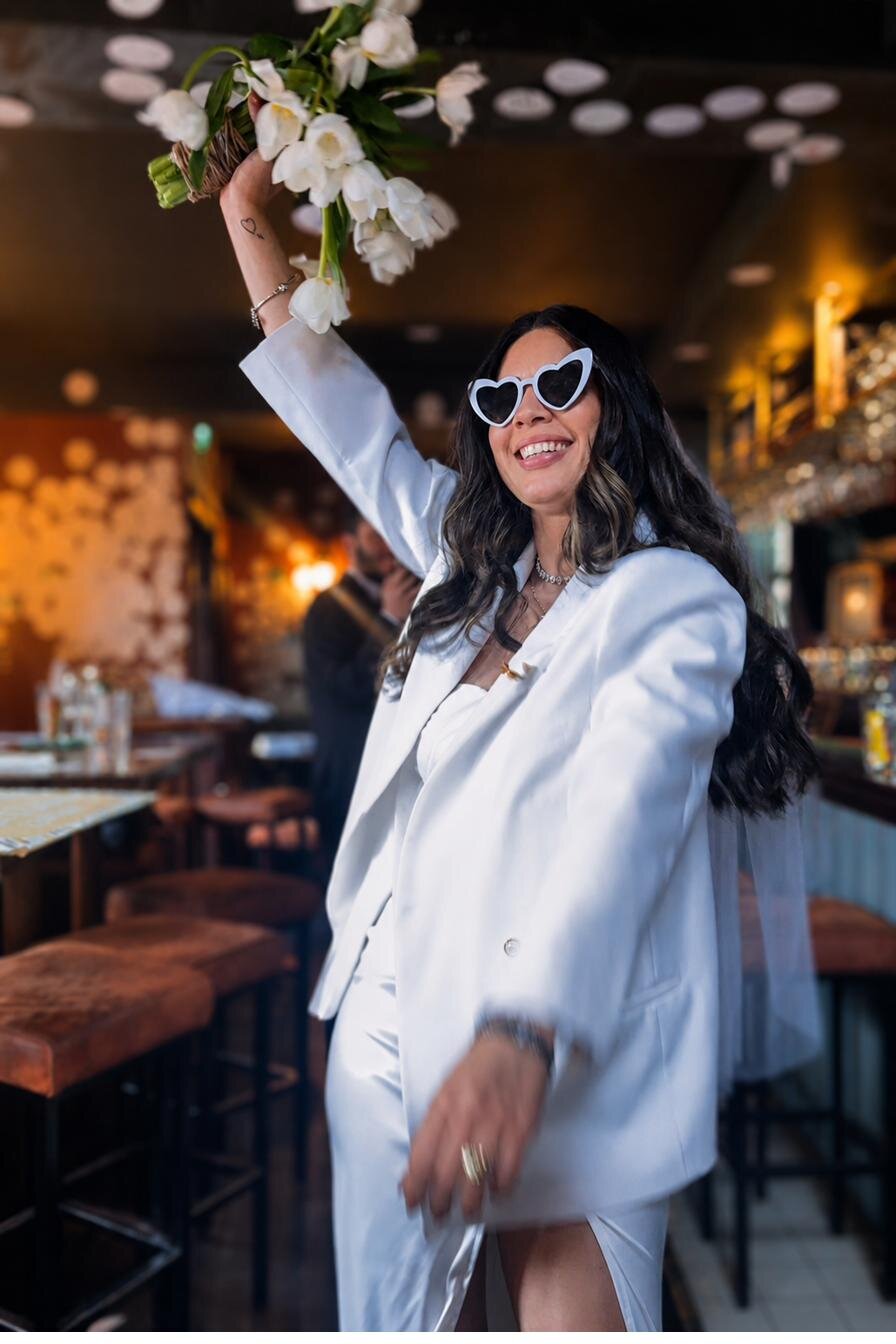 The bride celebrating with bouquet up